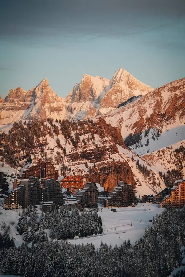Résidences en bois d’Avoriaz, skis aux pieds, sous des sommets embrasés au coucher du soleil