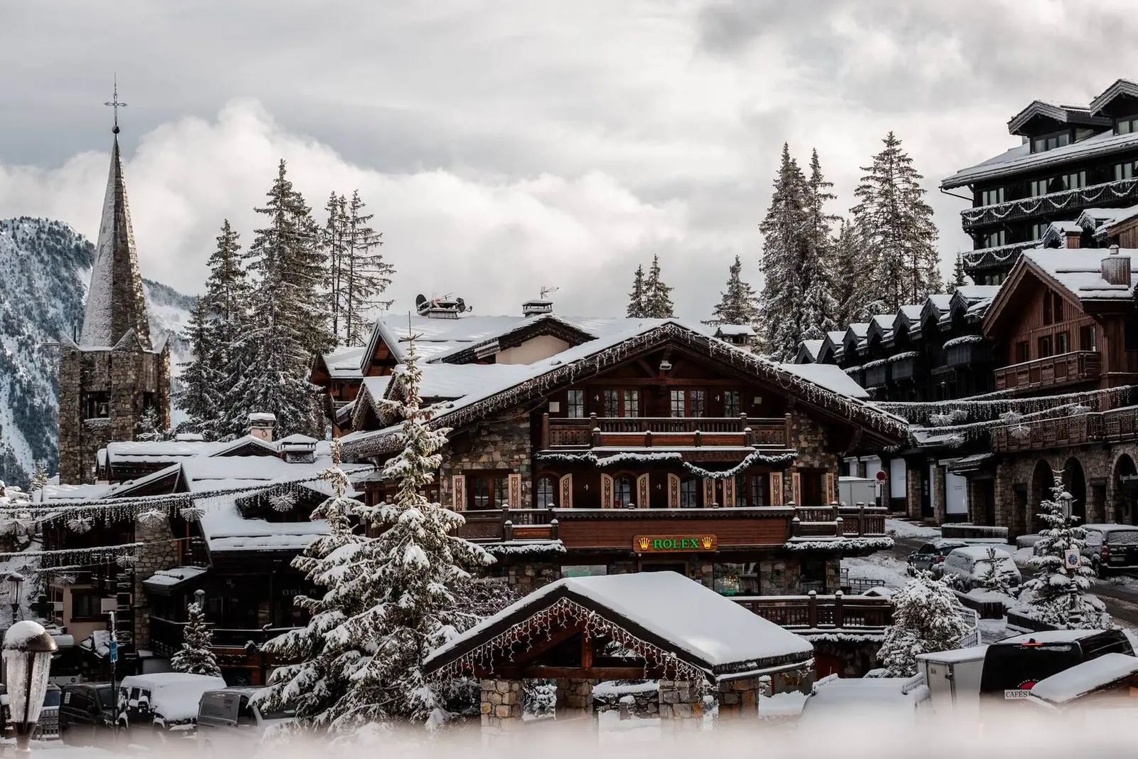 Verschneite Chalets und Kirchturm im Dorf Courchevel 1850, Französische Alpen