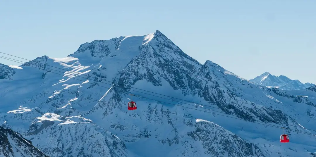 Rote Gondeln vor verschneiten Gipfeln in La Plagne, Paradiski