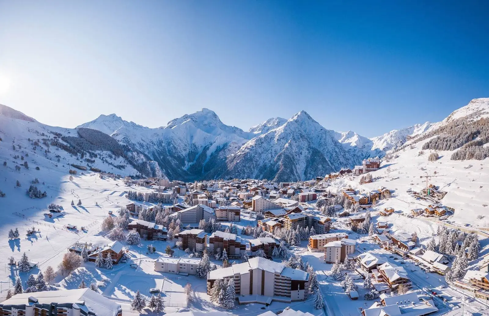 Vista aérea de la estación de esquí de Les 2 Alpes bajo nieve fresca, a los pies de los picos de los Écrins