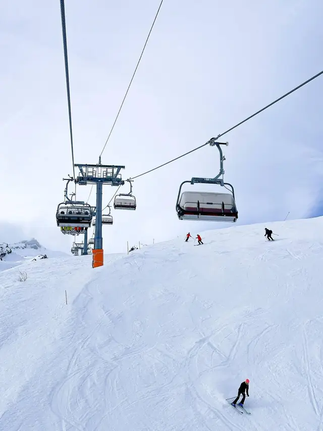 Skieurs sur une piste damée sous un télésiège aux Arcs, Paradiski