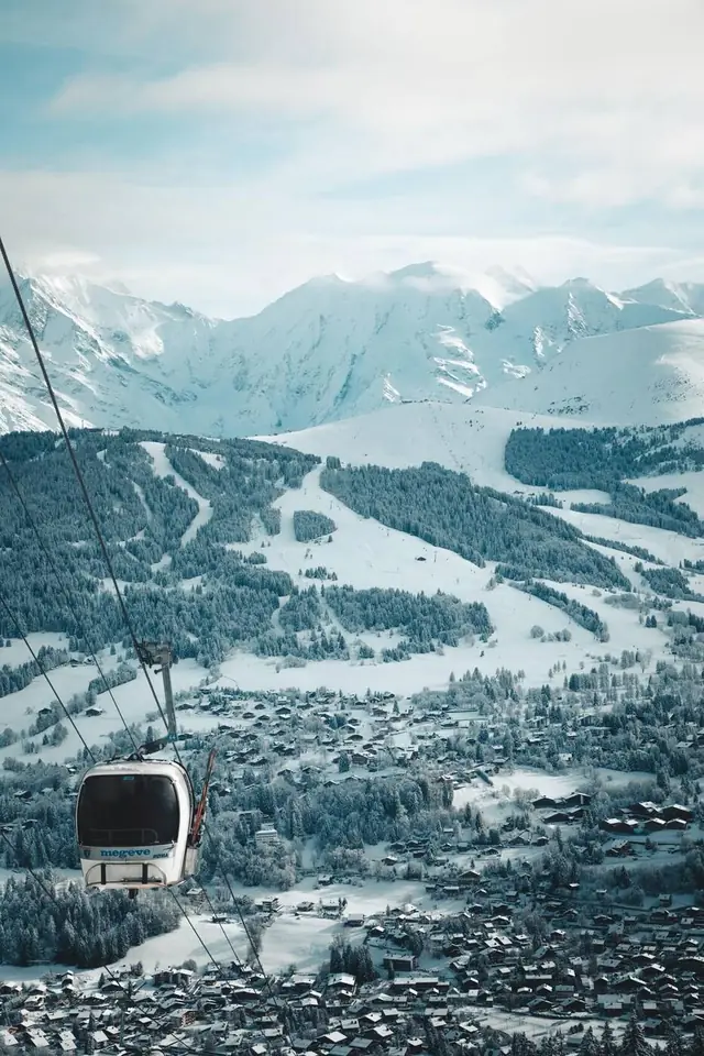 Télécabine de Megève au-dessus du village et des pistes enneigées, massif du Mont-Blanc en toile de fond